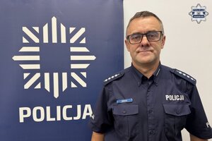 na zdjęciu dzielnicowy przy banerze z napisem policja