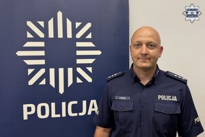 na zdjęciu dzielnicowy przy banerze z napisem policja
