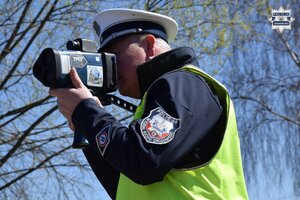 na zdjęciu policjant z miernikiem prędkości