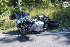 na zdjęciu leżący motocykl z uszkodzeniami