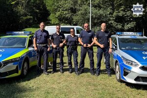 na zdjęciu policjanci przy radiowozach