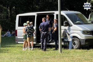 na zdjęciu osoby przy nieoznakowanym radiowozie