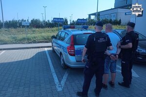 na zdjęciu policjanci z zatrzymanym przy radiowozie