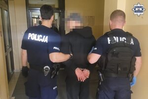 na zdjęciu policjanci z zatrzymanym mężczyzną