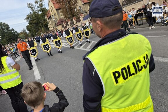 na zdjęciu policjant na jezdni, a przed nim pochód gwarkowski