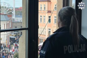 na zdjęciu policjantka wyglądająca przez okno