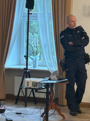 na zdjęciu sala w Pałacu w Rybnej oraz  siedzący przedstawiciele placówek oświatowych, a także policjant prowadzący szkolenie
